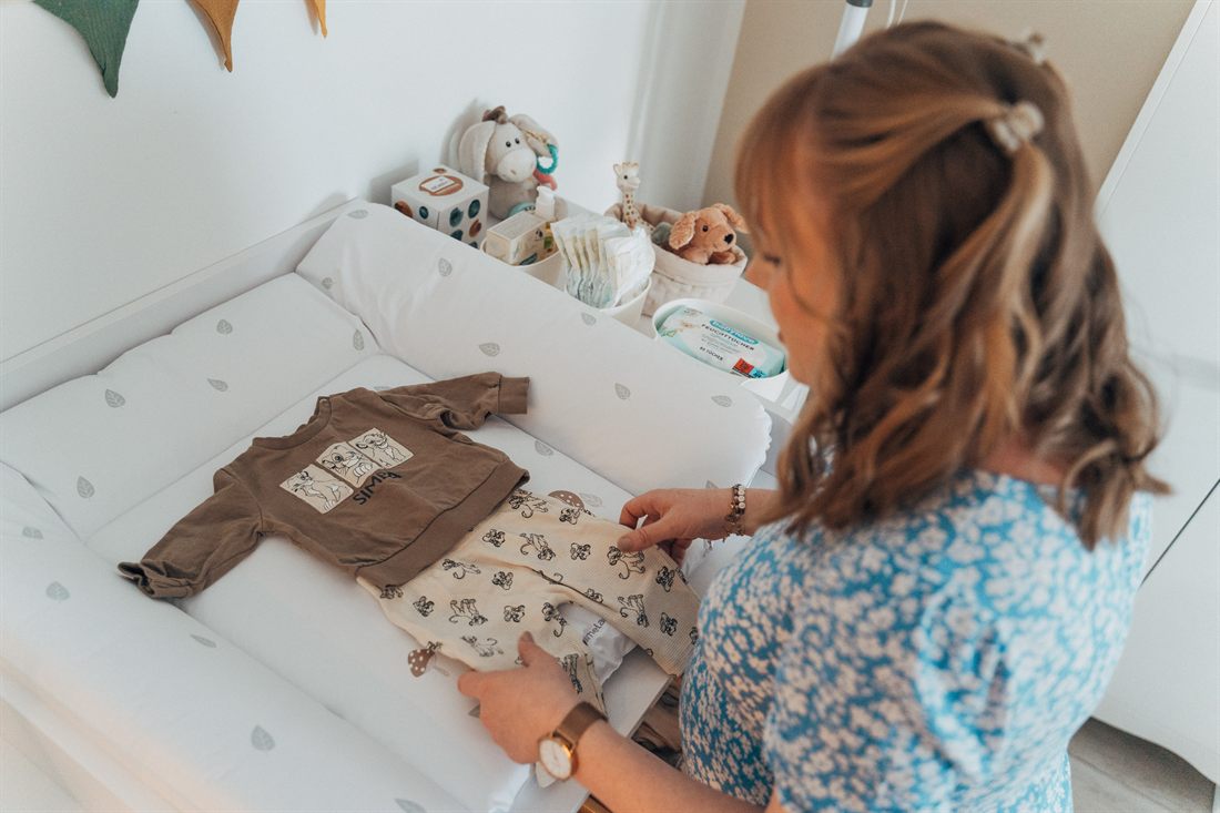 Babybauch-Shooting in Duisburg: Schwangere sortiert die erste Babykleidung